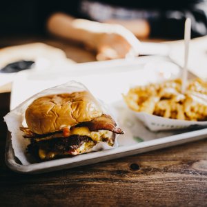 greasy hamburger and french fries on a tray