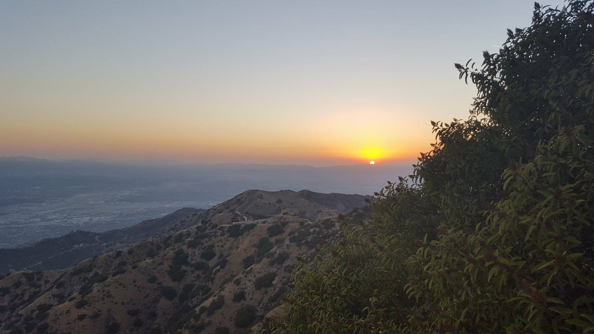 sun setting in the mountains in the desert